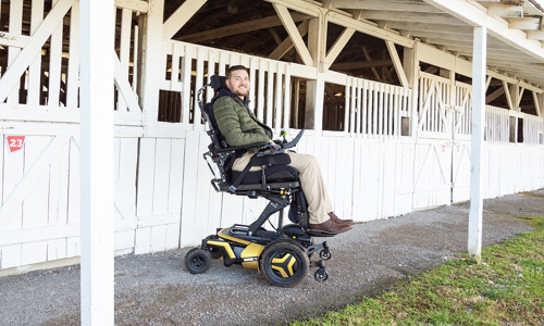 A man on a power wheelchair cruising in a stable