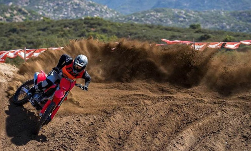 Man riding a 2022 Honda® CRF450R dirt bike on a dirt trail