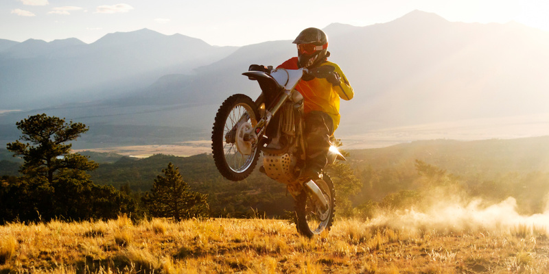 Old Man Biker on a Motorcycle Road with Mountains in Background