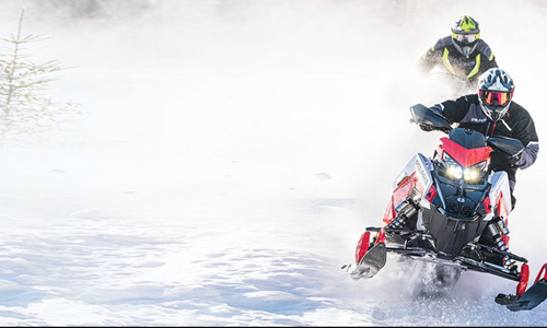 Rider blasting down a snowy trail on a 2021 Polaris INDY® Snowmobile