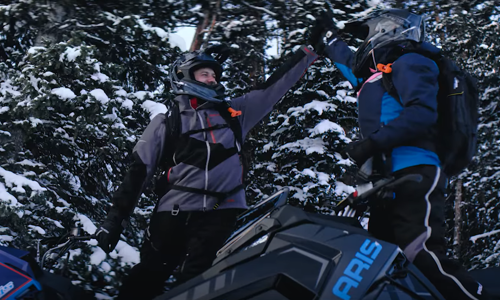 Two snowmobile riders hi fiving wearing TECH54 snowmobile gear