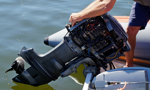 A man is replacing a propeller of a Yamaha® outboard.