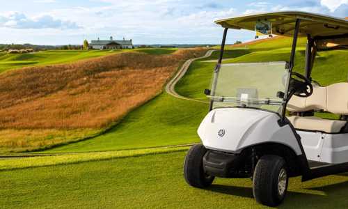 A white Yamaha® golf cart in the golf course.