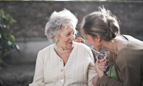 lady talking to smiling elderly woman