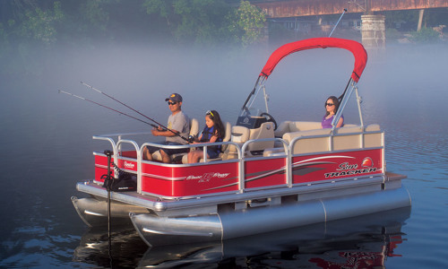 A father and his daughter are fishing while the mother is resting in a SUN TRACKER® pontoon boat on a lake.