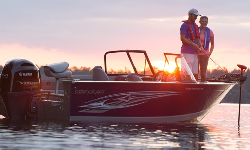 A couple on a boat powered by a Yamaha® outboard fishing during sunset.